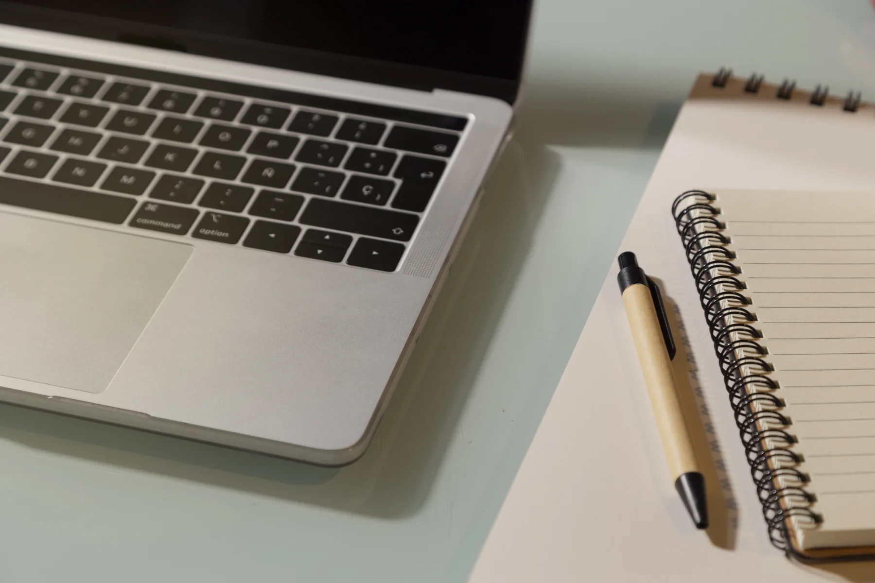 laptop-and-notepad-on-the-glass-table-top-view-2026-03-18-09-52-46-utc